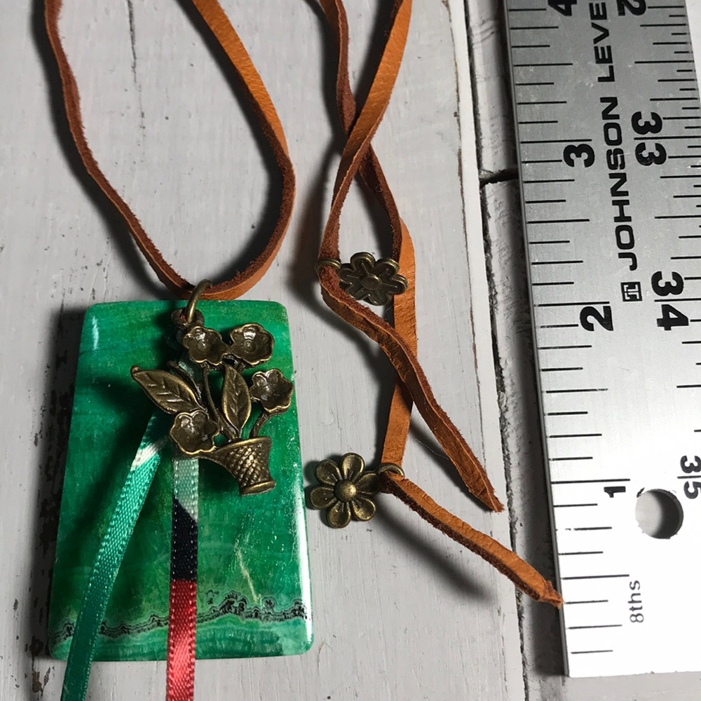 Large green malachite gemstone pendant on deerskin